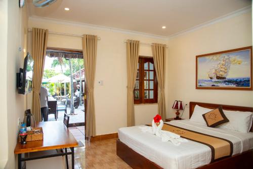 a bedroom with two beds and a desk and a window at PHƯƠNG NHUNG HOTEL in Phan Thiet