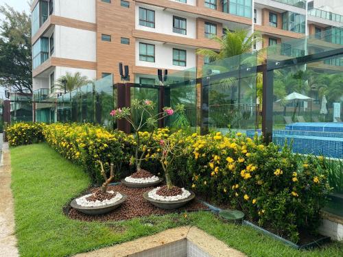 a row of flowers in front of a building at Luxor Paulo Miranda Frente ao mar in João Pessoa