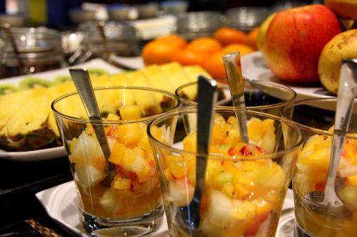 Un grupo de vasos llenos de fruta sobre una mesa. en Agua de Mar Hotel Boutique, en Vigo