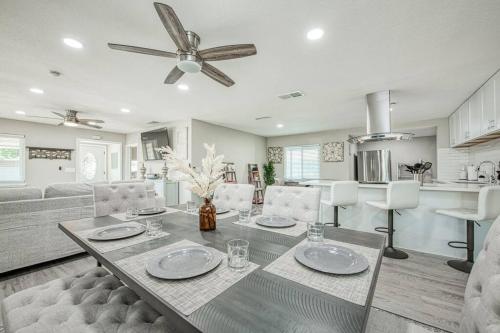 a living room with a table and a ceiling fan at Fun City Haven Spacious Retreat in Fresno in Fresno