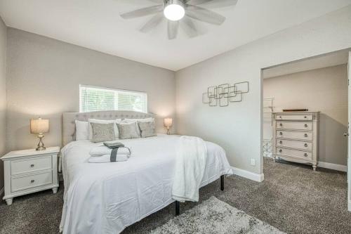 a bedroom with a white bed and a ceiling fan at Fun City Haven Spacious Retreat in Fresno in Fresno