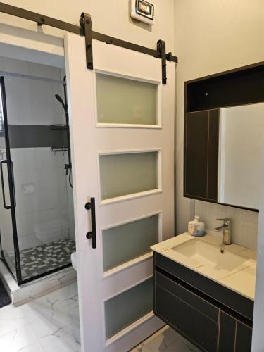 a bathroom with a shower and a sink and a mirror at Villa Serene in Lusaka