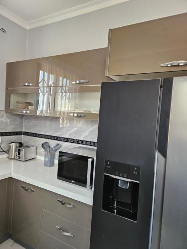 uma cozinha com um frigorífico preto e um micro-ondas em Villa Serene Lusaka em Lusaka