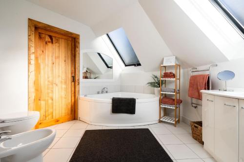 a bathroom with a tub and a sink at Country Apartment in Paraparaumu