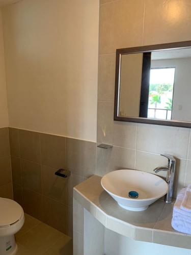 a bathroom with a sink and a toilet and a mirror at Finca del Rincón in Guadalupe