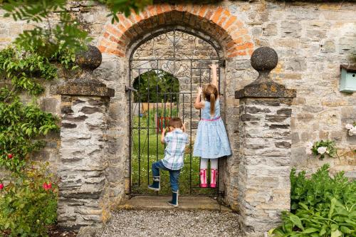 a boy and a girl jumping through a gate at Cossington Park House in Cossington