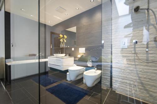 y baño con aseo, lavabo y ducha. en Chasa Emerita Moderne 3,5-Zimmer Terrassenwohnung mit Panoramablick, en Scuol