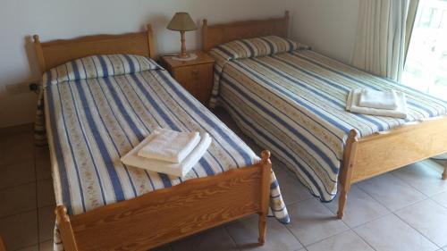 two twin beds in a room with a window at Pissouriana hotel Apartments in Pissouri
