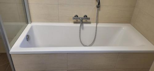 a white bath tub with a faucet in a bathroom at Ferienhaus Sole in Velden am Wörthersee