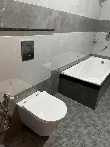 a bathroom with a toilet and a bath tub at Chaithanya Residency Near to NIT in Kunnamangalam