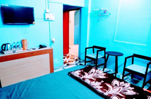 Pokój z dwoma krzesłami, stołem i telewizorem w obiekcie Hotel Shree Ram SIA Residency w mieście Gaja