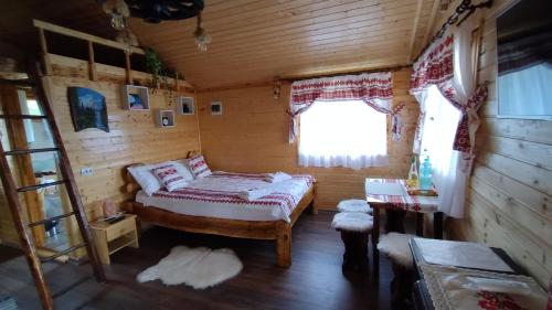 a bedroom in a log cabin with a bed and a window at Chalets du BF in Sighişoara