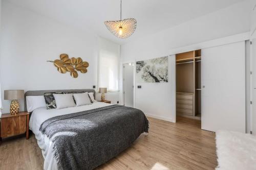 Habitación blanca con cama y lámpara de araña. en Ventas-luminoso y acogedor-a estrenar, en Madrid