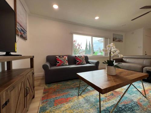 a living room with a couch and a table at Modern 3 King Beds, Beautiful Large Backyard, WFH, Long Stays, Waterfall, WI-FI, FWY, 25 mins to Beach in Thousand Oaks