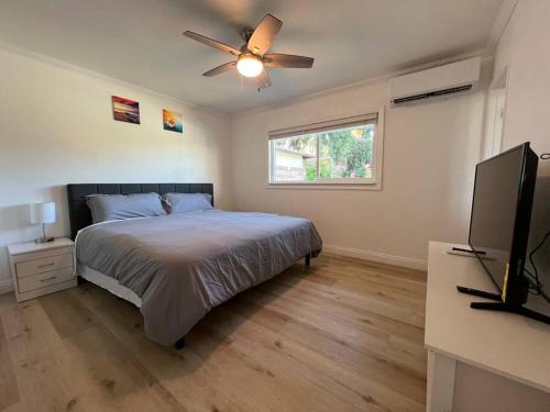 a bedroom with a bed and a flat screen tv at Modern 3 King Beds, Beautiful Large Backyard, WFH, Long Stays, Waterfall, WI-FI, FWY, 25 mins to Beach in Thousand Oaks