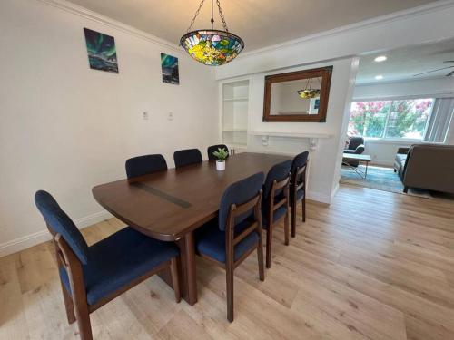 a dining room table and chairs in a living room at Modern 3 King Beds, Beautiful Large Backyard, WFH, Long Stays, Waterfall, WI-FI, FWY, 25 mins to Beach in Thousand Oaks
