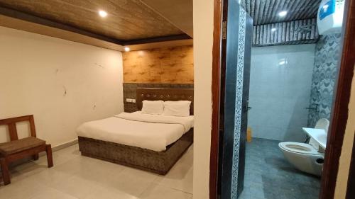 een slaapkamer met een bed en een badkamer met een douche bij Shimla Royale - Near Mall Road Free Pickup From Railway Station Shimla in Shimla