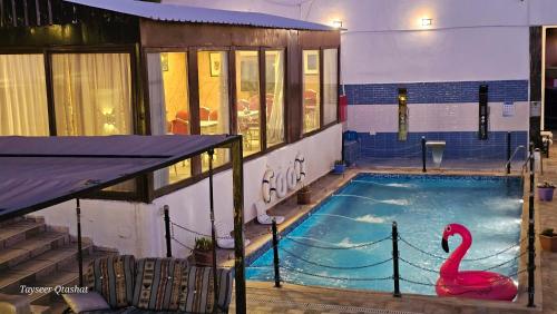 a swimming pool with a pink swan in it at Al Namteh Lodge in ‘Ābil