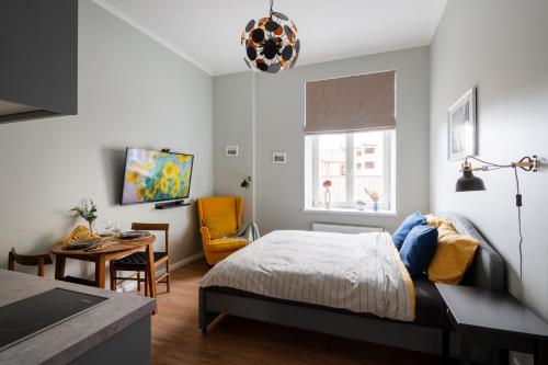 a bedroom with a bed and a table and a chair at Historical House Apartments in Rīga