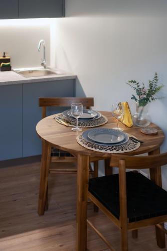 a wooden table with two plates and glasses on it in a kitchen at Historical House Apartments in Rīga