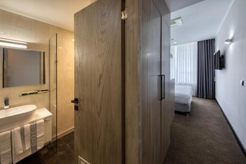 a bathroom with a sink and a toilet and a mirror at Expocore Hotel in Yerevan