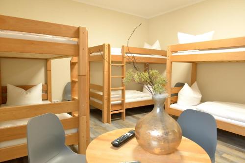 a room with a table and chairs and bunk beds at Hostel & Pension Alte Brauerei in Eisenach