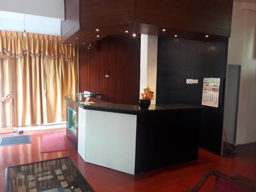 a kitchen with a black and white counter and a window at Hotel Kingland in Ruwanwella