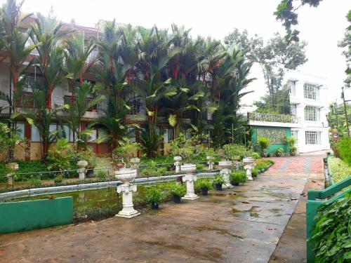 a garden with rows of plants in front of a building at Hotel Kingland in Ruwanwella