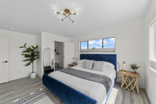 Un dormitorio con una cama azul y blanca y una ventana en New DRIFTWOOD SHORES ROAD HOUSE CAMANO, en Driftwood Shores