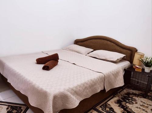 a bed with a brown pillow on top of it at Dhana Palace Homestay Gelang Patah in Johor Bahru