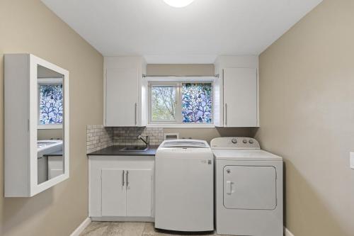 Una cocina con gabinetes blancos y lavavajillas. en New Broadway House Mount Vernon, en Mount Vernon