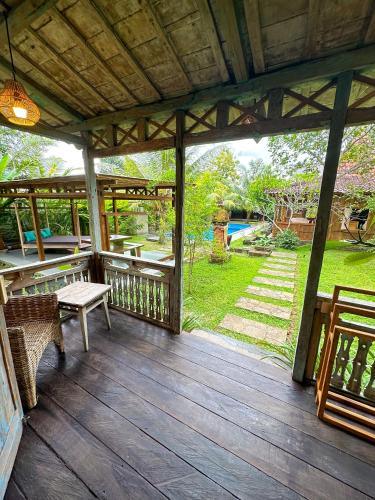 a wooden porch with a table and benches on it at Nunu Bali Eco Friendly Retreat in Canggu