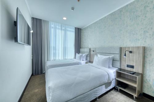 Un pat sau paturi într-o cameră la Expocore Hotel