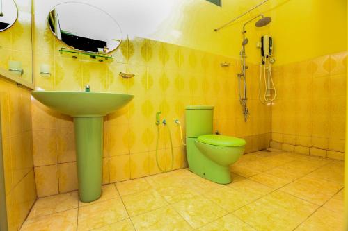uma casa de banho com um WC verde e um lavatório em Hotel Kingland em Ruwanwella