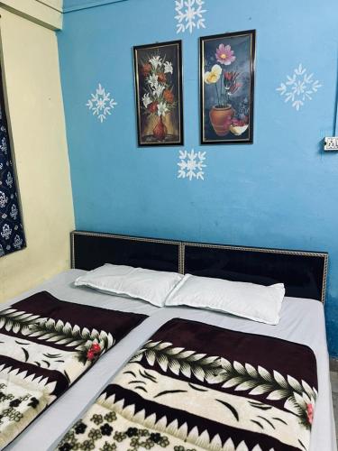 a bed with a blue wall with snow at Hotel Virdh Badri in Joshīmath