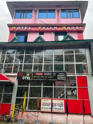 a pink building with a sign in front of it at Hotel Virdh Badri in Joshīmath