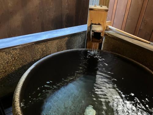 a water fountain in a black bowl of water at Toushinan Komeya in Ito