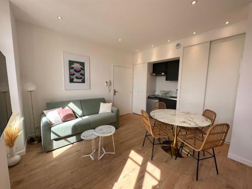 uma sala de estar com um sofá e uma mesa em Résidence Terminus - appartements em Sainte-Maxime