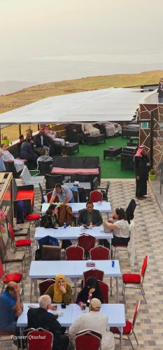 a group of people sitting at tables under a tent at Al Namteh Lodge in ‘Ābil
