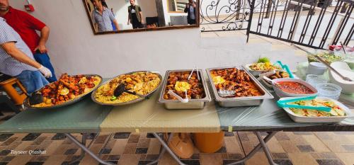 a table with several trays of food on it at Al Namteh Lodge in ‘Ābil