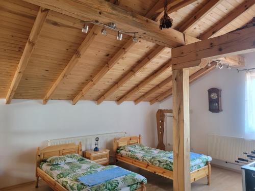 2 Betten in einem Zimmer mit Holzdecken in der Unterkunft Къща за гости - Еделвайс, гр. Габрово in Gabrowo