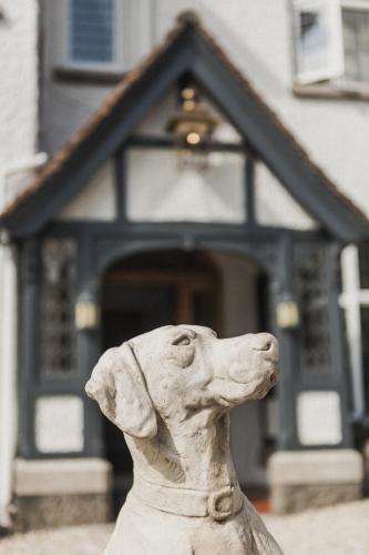 a statue of a dog in front of a house at Merchants Manor Spa in Falmouth