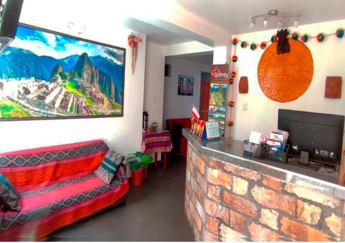 a living room with a couch and a tv on a wall at Qolmay Hostel Cusco in Cusco