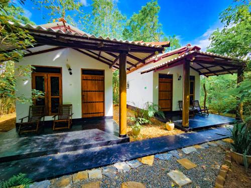 a house with a pergola and a patio at Bright Sun Safari in Udawalawe