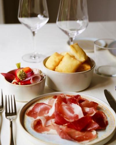 a table with plates of food and glasses of wine at PALAZZO DE' ROSSI HOTEL in Sasso Marconi