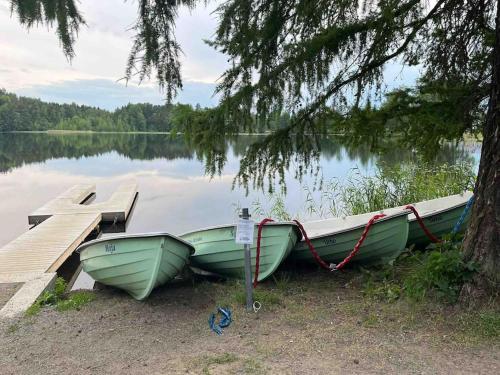 two boats parked next to a dock on a lake at Rauhallinen kaksio Urpolassa in Mikkeli