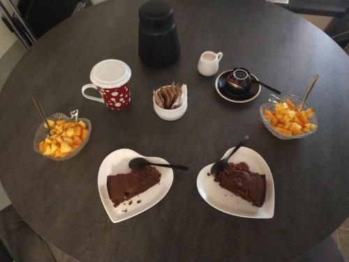 a table with two slices of cake and bowls of fruit at LA TANA DELLA VOLPETTA - Bed & Breakfast in Stella