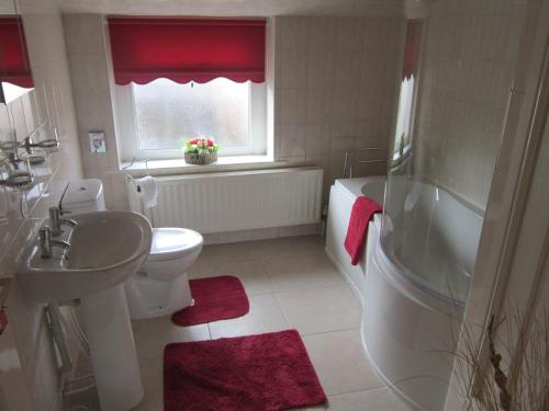 a bathroom with a sink and a toilet and a tub at The Sycamore Tree in Longtown