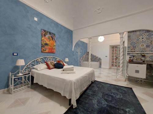 1 dormitorio con cama y pared azul en GL Golden City Apartments, en Catania