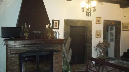a living room with a fireplace and a television at Hotel Rural Palacio de Galceran in Sotiello